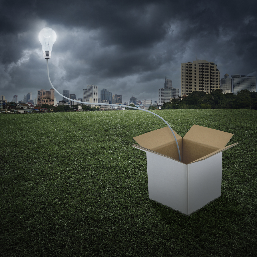 Glowing Light Bulb Float Over Box On City, Think Outside The Box